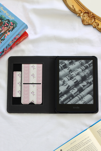 Kindle device in a case on a white surface with books in the background