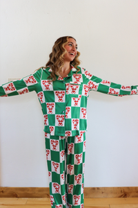 Woman wearing a green and red patterned dress with long sleeves and a checkered design.