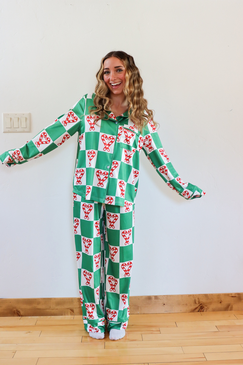 Woman wearing a green and red checkered onesie with a pattern of white dogs on a white background.