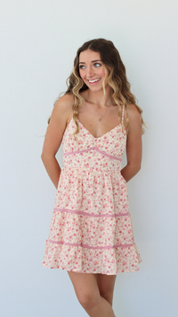 Woman wearing a floral dress against a plain background