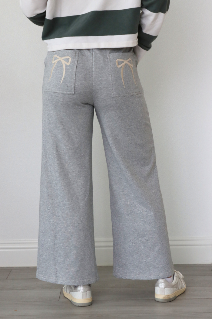 girl wearing gray sweatpants with bow pocket detailing