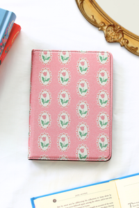 Pink kindle with floral pattern on a white surface