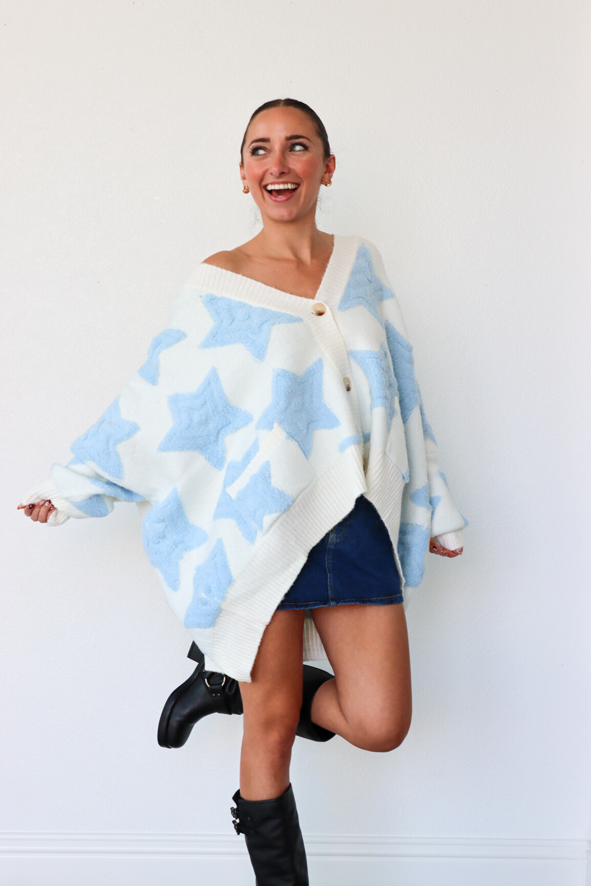 Woman wearing a blue and white patterned poncho against a white background