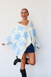 Woman wearing a blue and white patterned poncho against a white background
