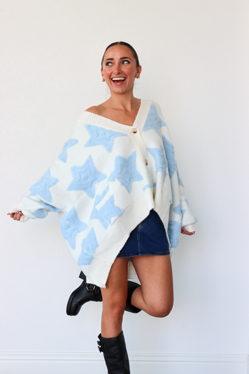 Woman wearing a blue and white patterned poncho against a white background