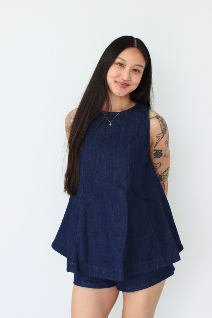 Woman wearing a navy blue outfit set against a white background