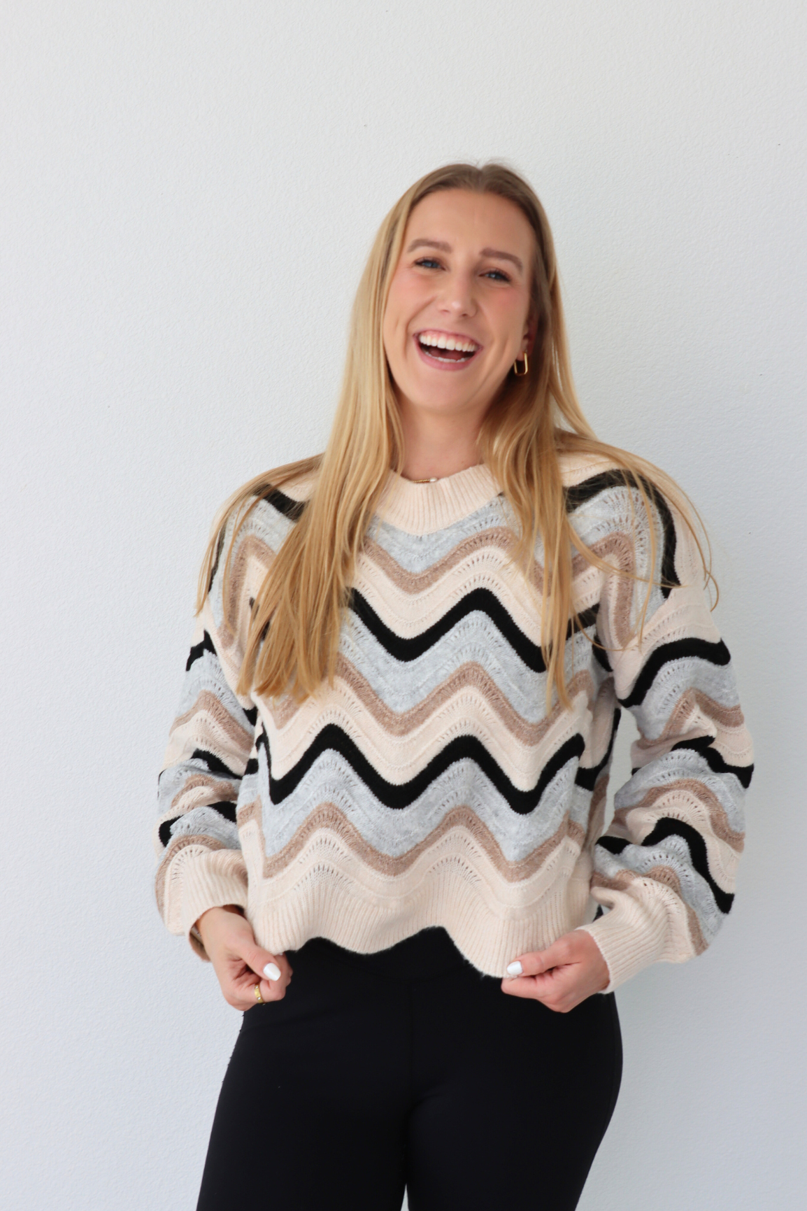 Woman wearing a striped sweater against a plain background