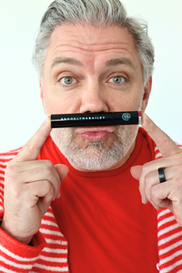 Man holding a Brooklyn & Bailey product in front of his mouth against a white background
