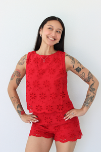 Woman wearing a red flower eyelet short set with a white background