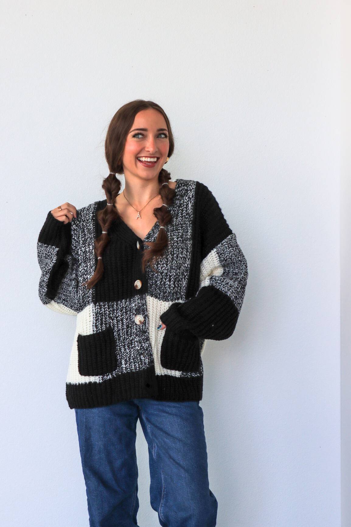 Woman wearing a checkered cardigan with a white background