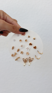Collection of gold and pearl earrings on a white background
