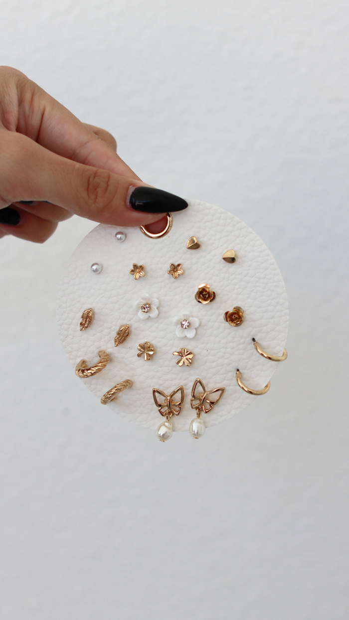 Collection of gold and pearl earrings on a white background