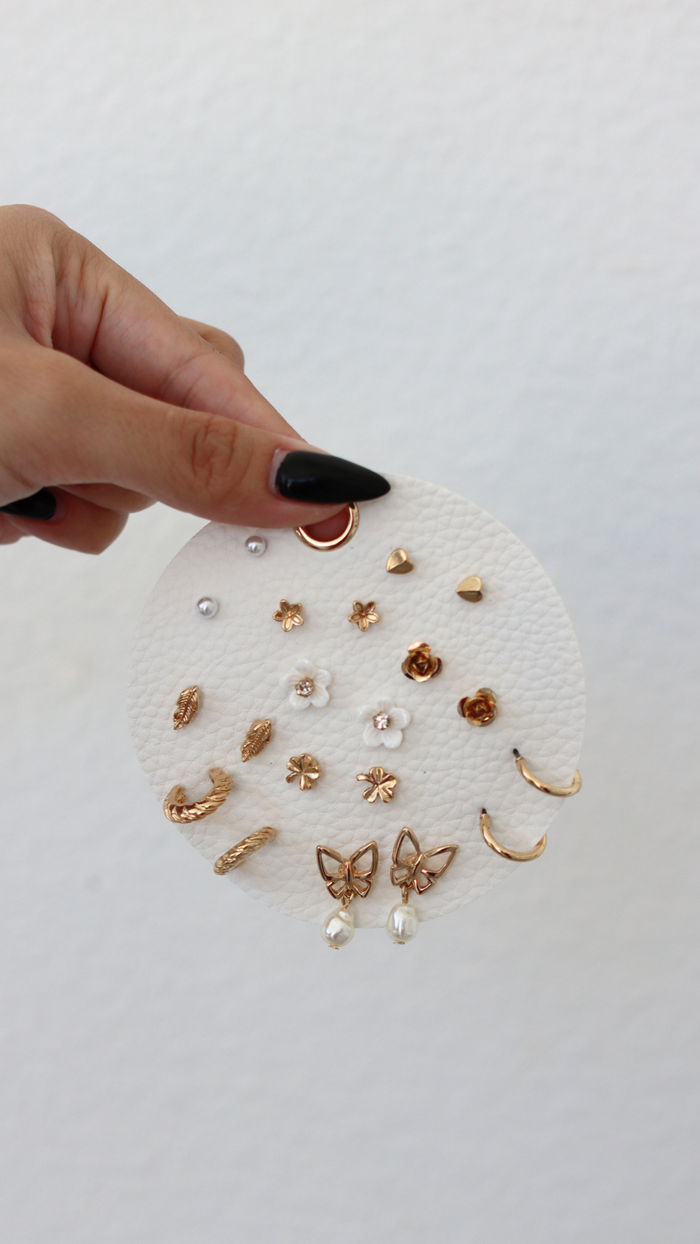 Collection of gold and pearl earrings on a white background