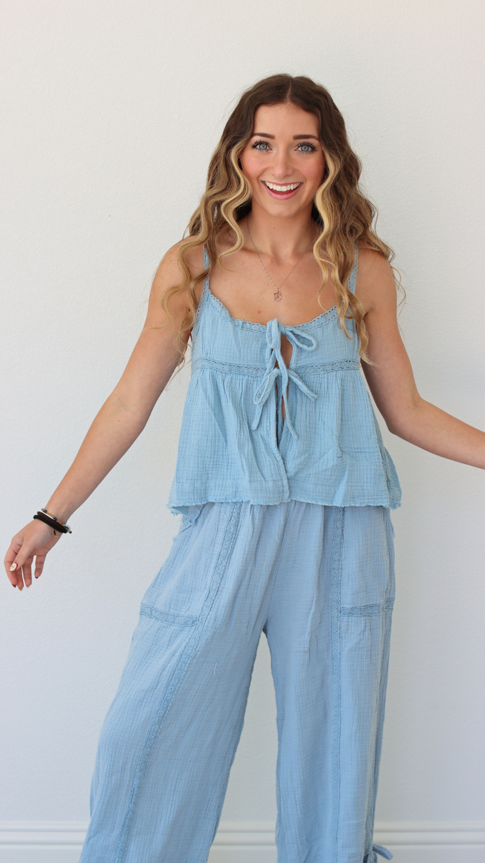 Woman wearing a light blue jumpsuit against a white background