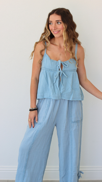 Woman wearing a light blue jumpsuit against a white background