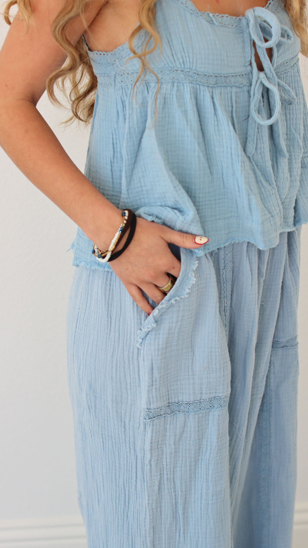 Light blue jumpsuit worn by a person with a plain background