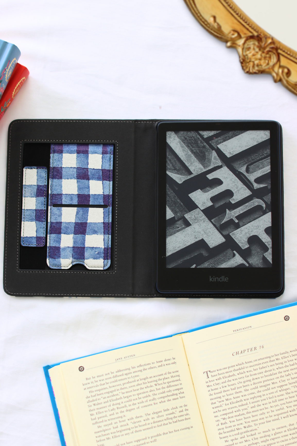 Black leather kindle case with a plaid pattern and geometric interior, placed on a white surface.