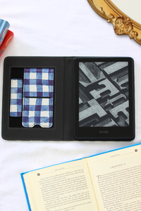 Black leather kindle case with a plaid pattern and geometric interior, placed on a white surface.