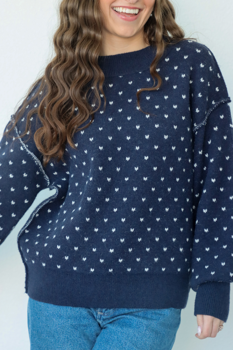 girl wearing navy heart knit sweater