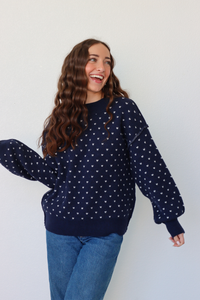 girl wearing navy heart knit sweater