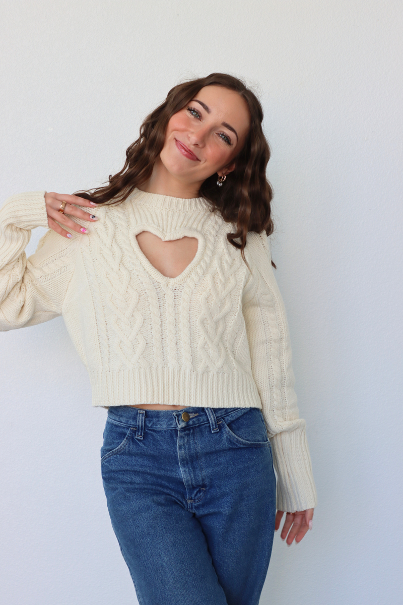 girl wearing cream heart cutout sweater