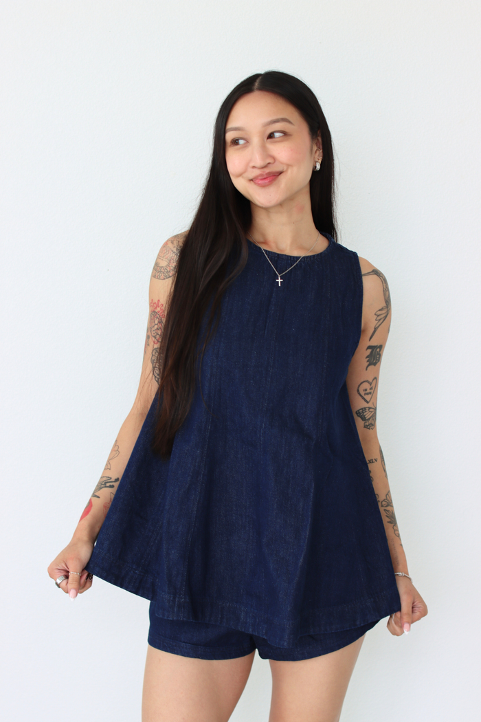Woman wearing a navy blue outfit set against a white background