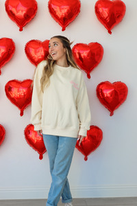 girl wearing cream crewneck sweatshirt with "sweet heart" and "sweet treat"graphic