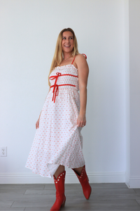 girl wearing white dress with red heart detailing