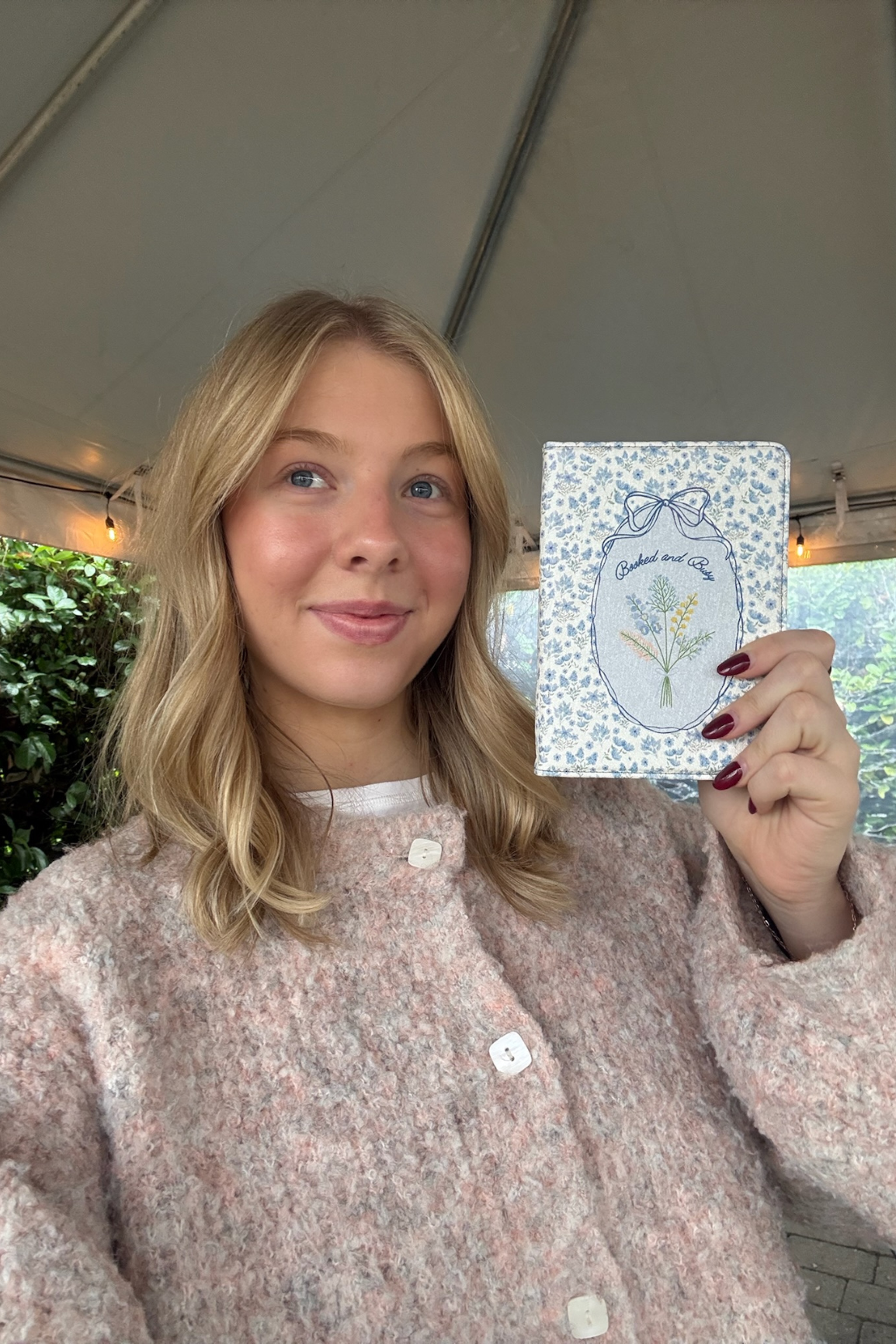 Person holding a card with a floral design outdoors
