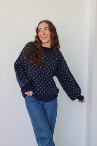 girl wearing navy heart knit sweater