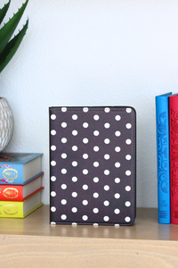 Polka dot kindle on a shelf with colorful books