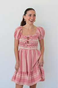 Woman wearing a red gingham mini dress with puff sleeves against a white background