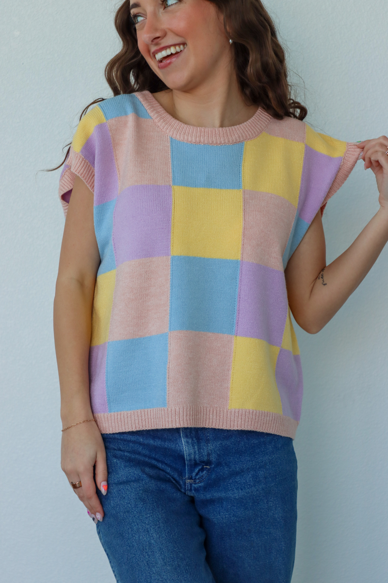 girl wearing blue, yellow, and purple knit short sleeve top