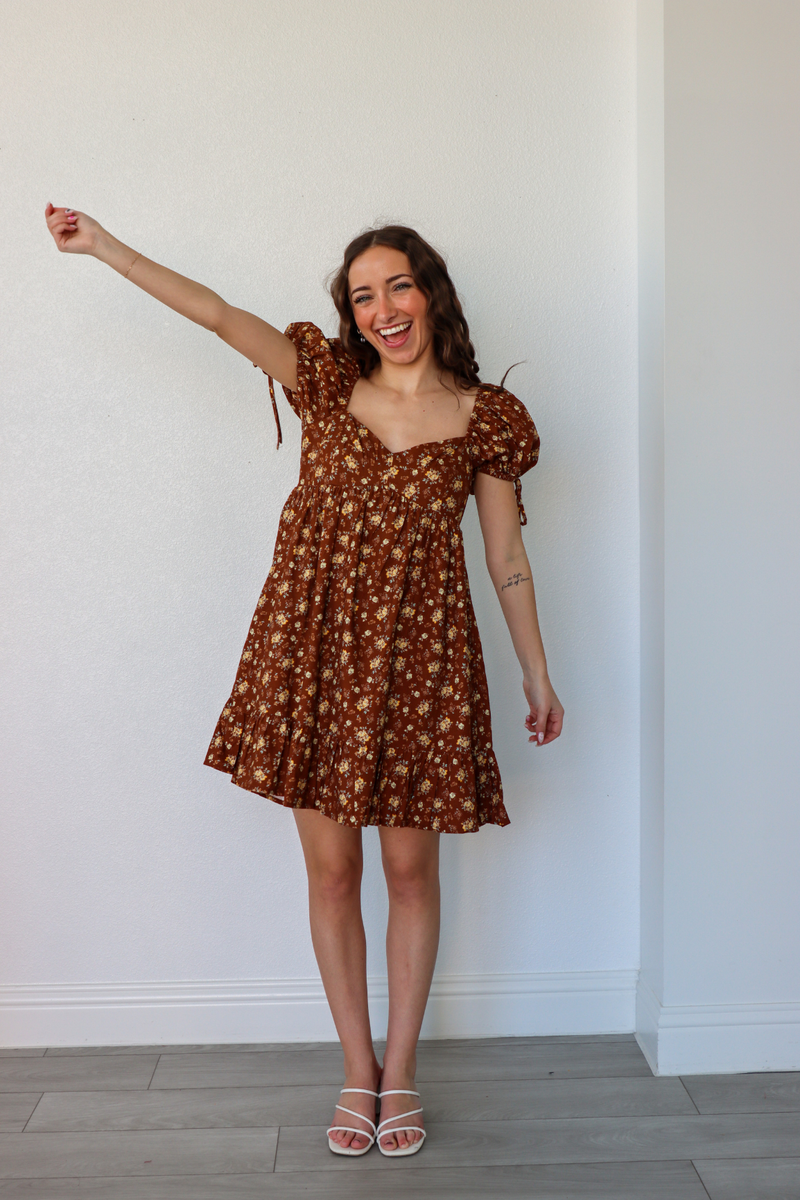 girl wearing short brown floral dress