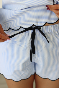 Close-up of a person wearing a blue and white striped pajama outfit with a black string.