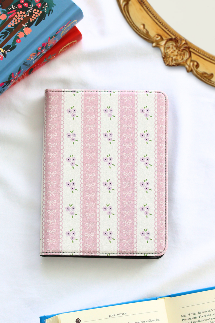 Pink and white striped kindle with floral patterns on a white surface