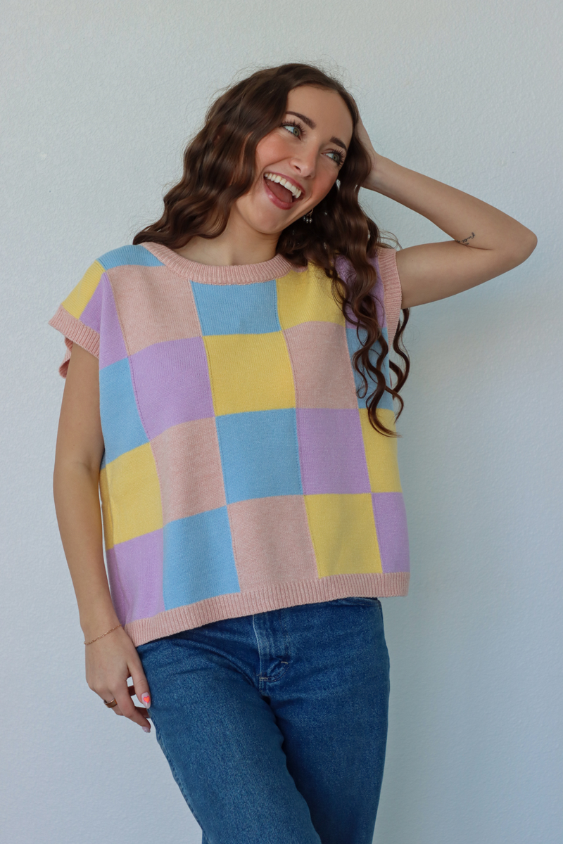 girl wearing blue, yellow, and purple knit short sleeve top