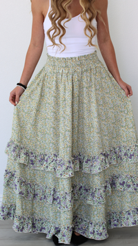 Woman wearing a floral tiered skirt with a plain background