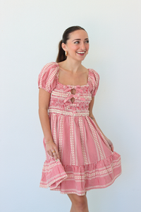 Woman wearing a red gingham mini dress with puff sleeves against a white background