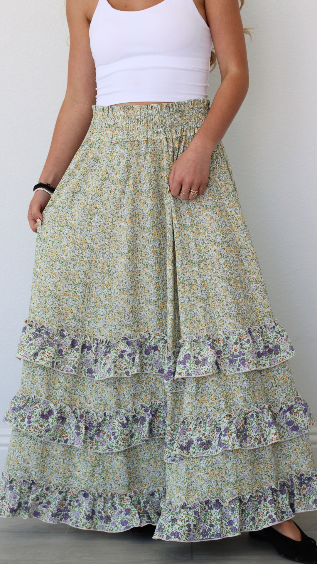 Woman wearing a floral tiered skirt with a plain background