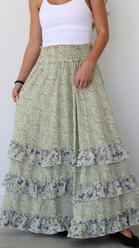 Woman wearing a floral tiered skirt with a plain background