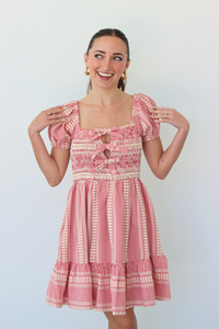 Woman wearing a red gingham mini dress with puff sleeves against a white background