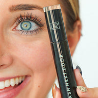 Woman holding a 'Lash Next Doctor' eyelash product with a blurred background