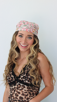 Woman wearing a leopard print top and colorful headband against a white background