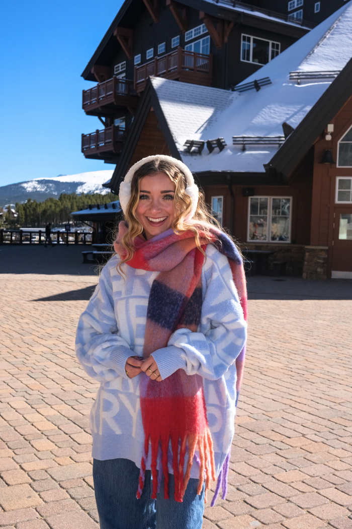 Woman in winter clothing standing in front of a snow-covered building