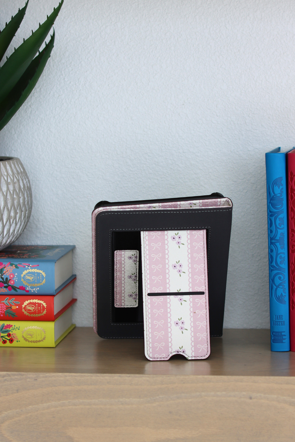 Decorative kindle with floral design on a shelf with books