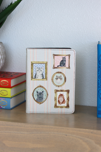 Kindle Case with cat illustrations on a shelf with books