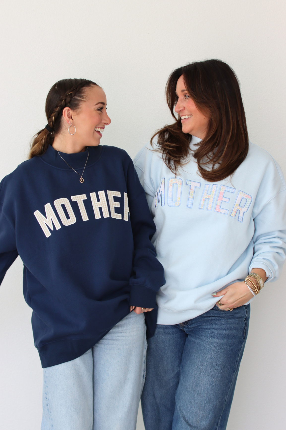 Two women wearing MOTHER sweatshirts