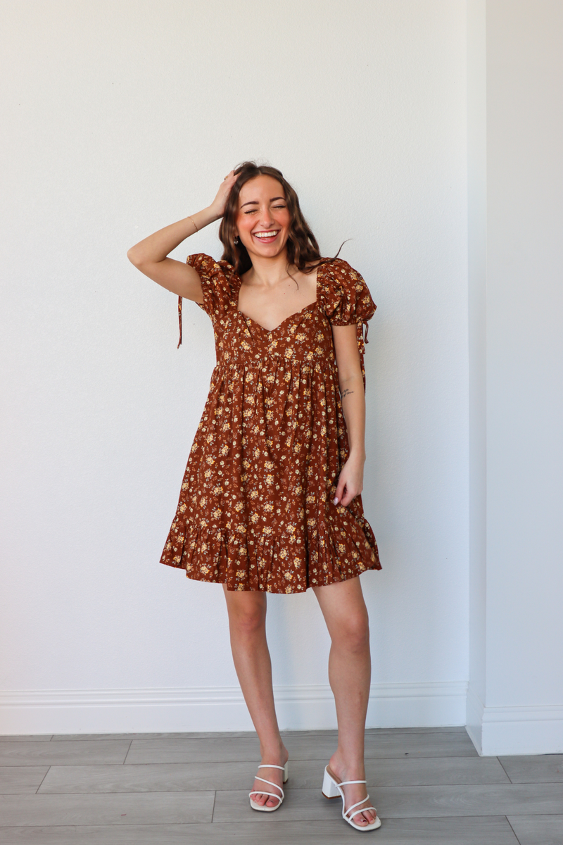 girl wearing short brown floral dress