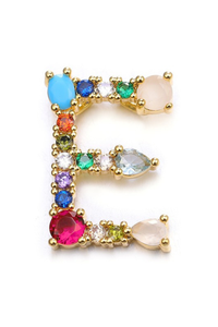 Gold earring with multicolored gemstones on a white background